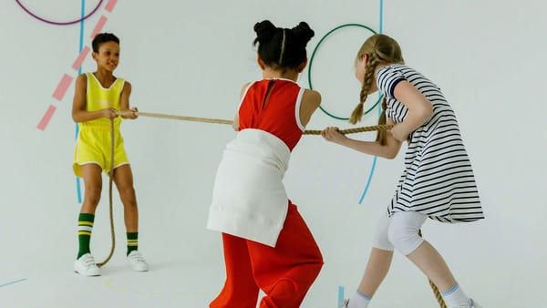 Children pulling on a rope in opposing directions.